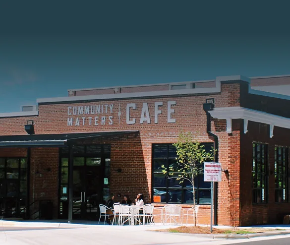 brick community café storefront with outdoor seating and clear blue sky., community matters cafe, charlotte