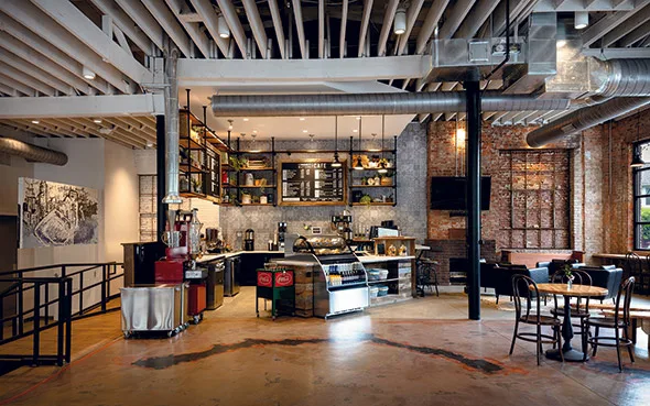 industrial loft coffee shop with exposed brick, concrete floors, and open shelving., community matters cafe, charlotte