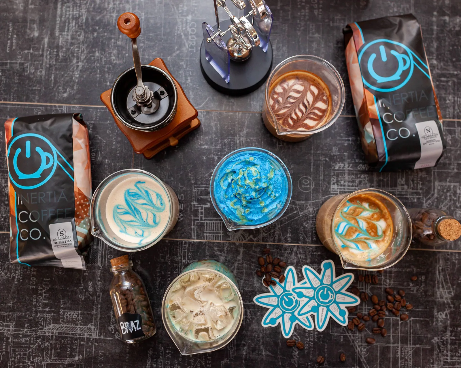 coffee display with various latte art designs and inertia coffee co. branded packaging and accessories., corter coffee roaste