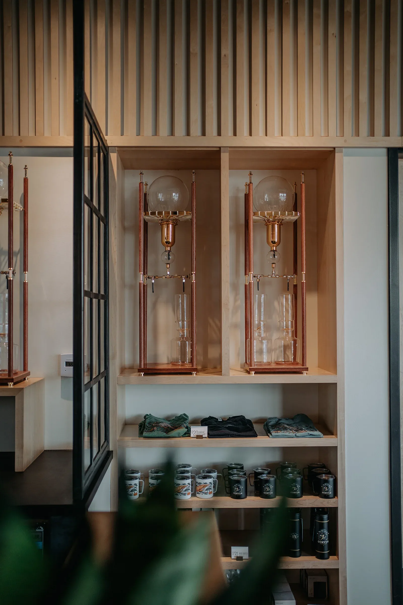 copper laboratory glassware displays with tea containers and folded textiles below., corvus coffee roasters, arvada