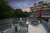 rooftop terrace at dusk with seating, plants, and city views., courtyard revibe - cafe & restaurant | dwarka, delhi