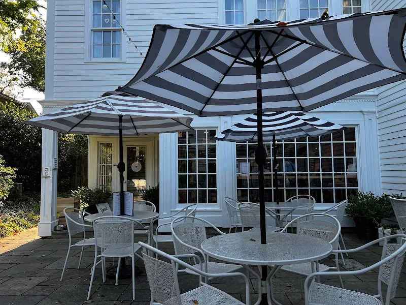 striped umbrellas shade patio seating area outside blue house., cowbell kitchen, washington