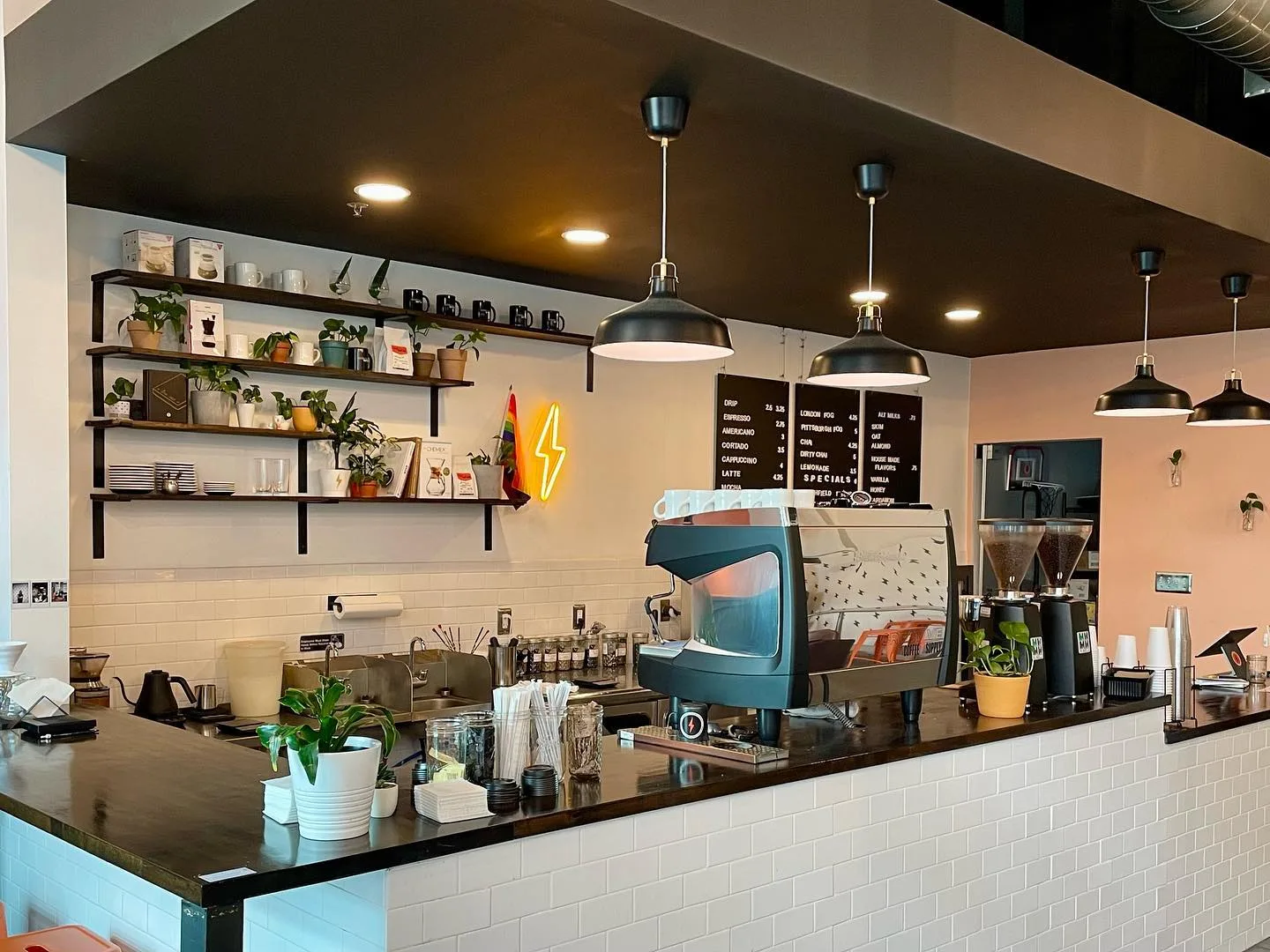 modern coffee shop counter with espresso machine, pendant lights, and shelving displays., creative coffee & supply, pittsburg