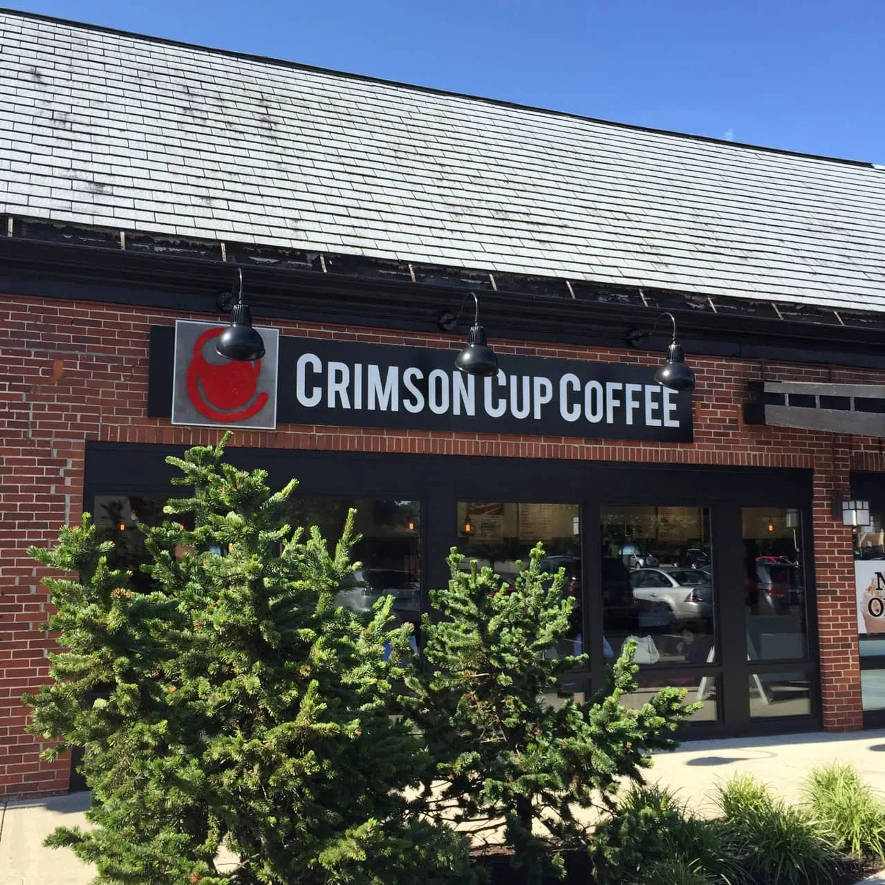 crimson cup coffee storefront with brick facade, large windows, and hanging pendant lights., crimson cup coffee shop - upper 