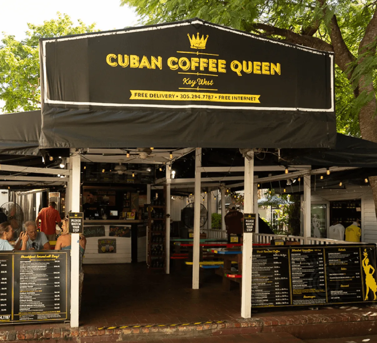 cuban coffee queen storefront in key west with black awning and yellow crown logo., cuban coffee queen waterfront, key west