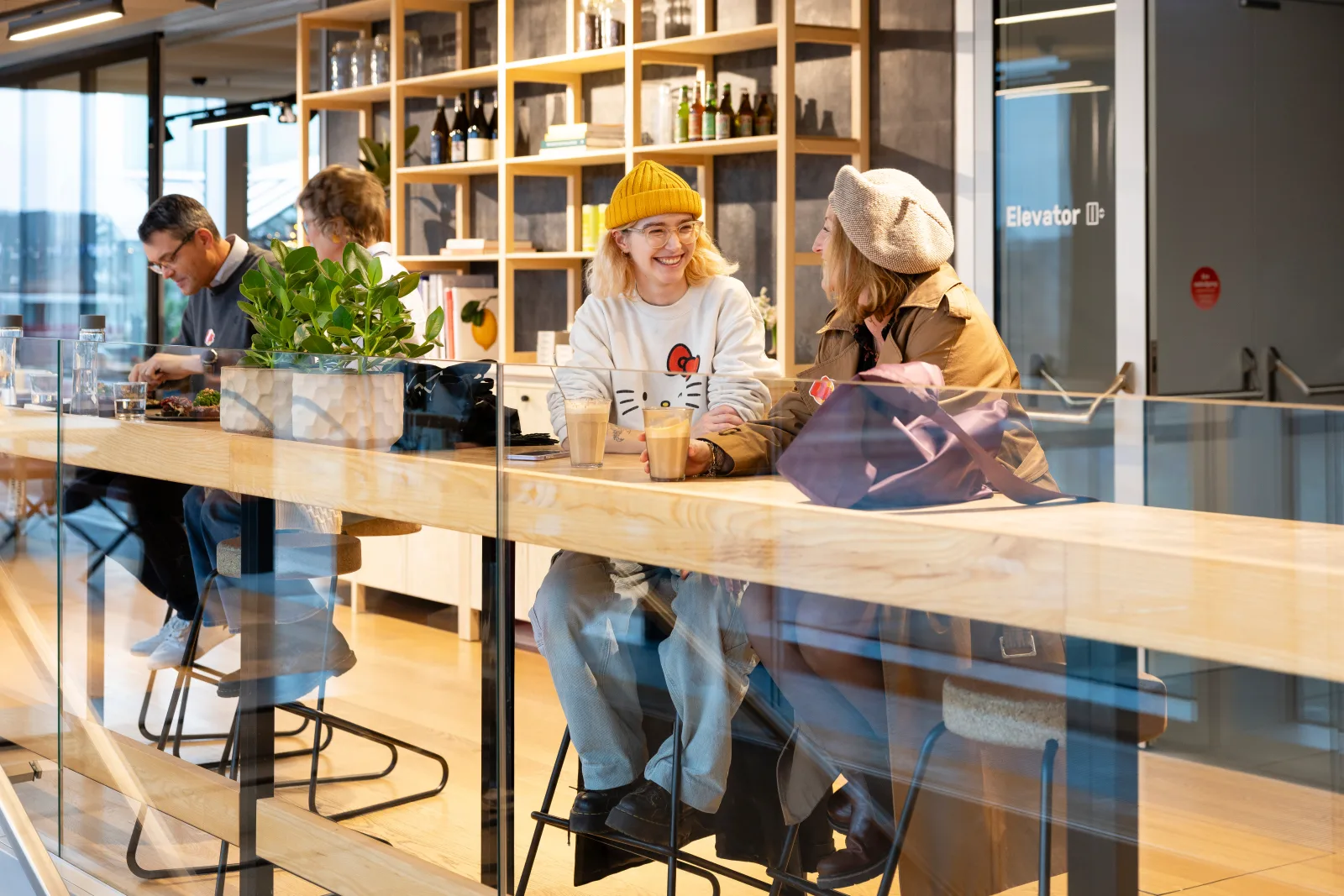 modern café interior with customers at wooden counter, shelving, and city views., danish architecture center, copenhagen