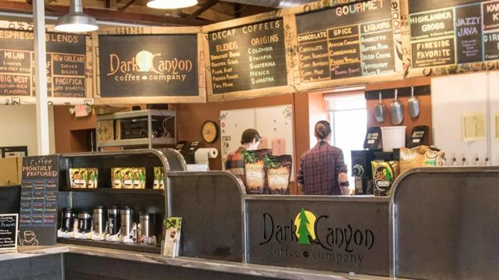 dark canyon coffee company counter with staff, menu boards, and retail products displayed., dark canyon coffee co, south dako