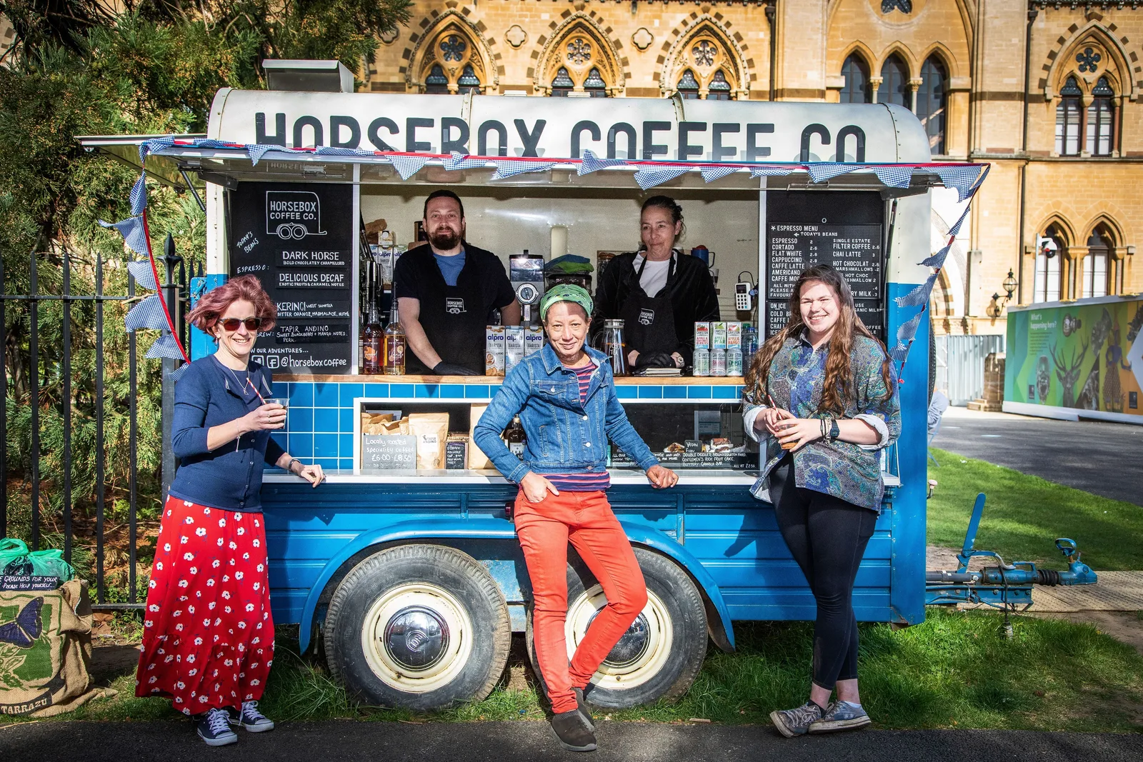 blue vintage coffee truck with five staff members posing at gothic stone building., dark horse coffee company, plant city
