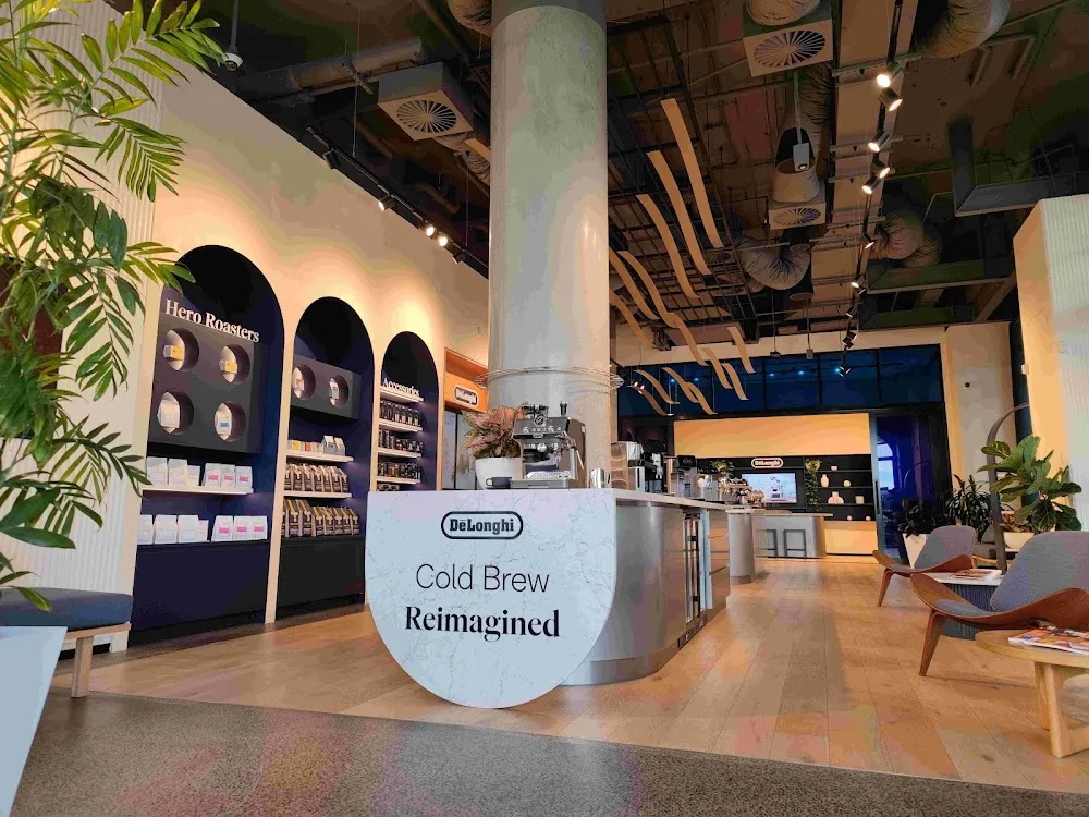 modern coffee shop interior featuring delonghi cold brew display and hero roasters branding., de'longhi coffee lounge, zetlan