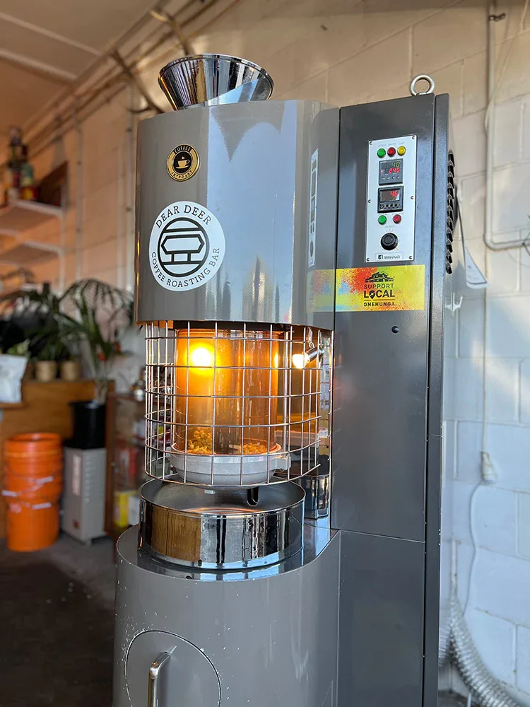 professional coffee roaster with glowing heating chamber and control panel mounted on wall., dear deer coffee roasting bar on