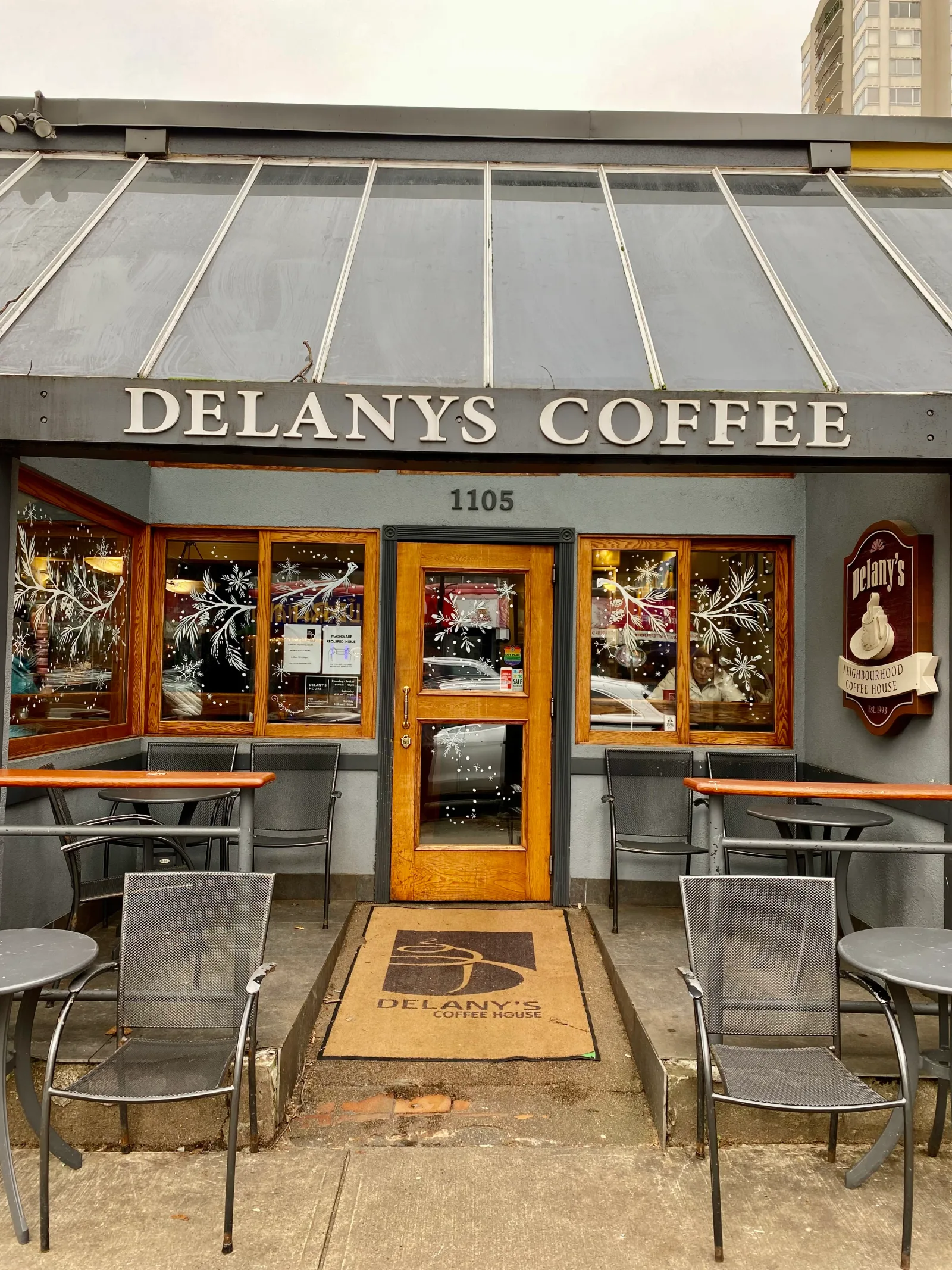 delanys coffee storefront with wooden door, metal chairs, and holiday decorations., delany's coffee house, north vancouver