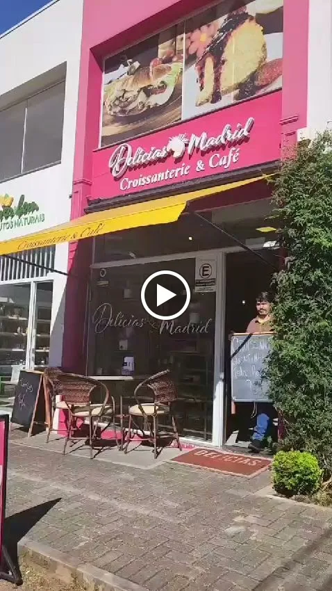 pink storefront with "delicia's madrid" croissanterie and café signage, outdoor seating visible., delicias madrid - croissant