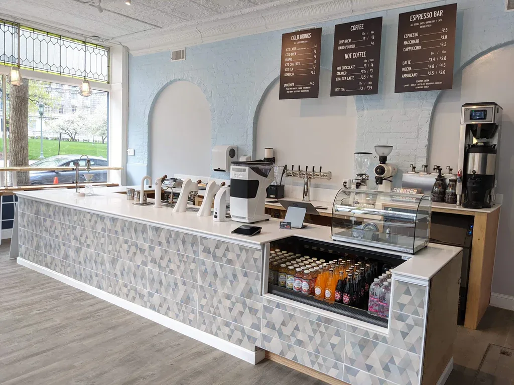 modern minimalist coffee shop counter with espresso machines and menu boards overhead., denim coffee, harrisburg