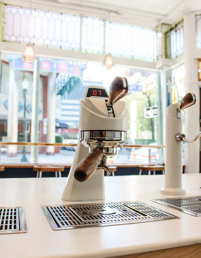modern espresso machine with cream-colored portafilter in bright, minimalist café setting., denim coffee, harrisburg