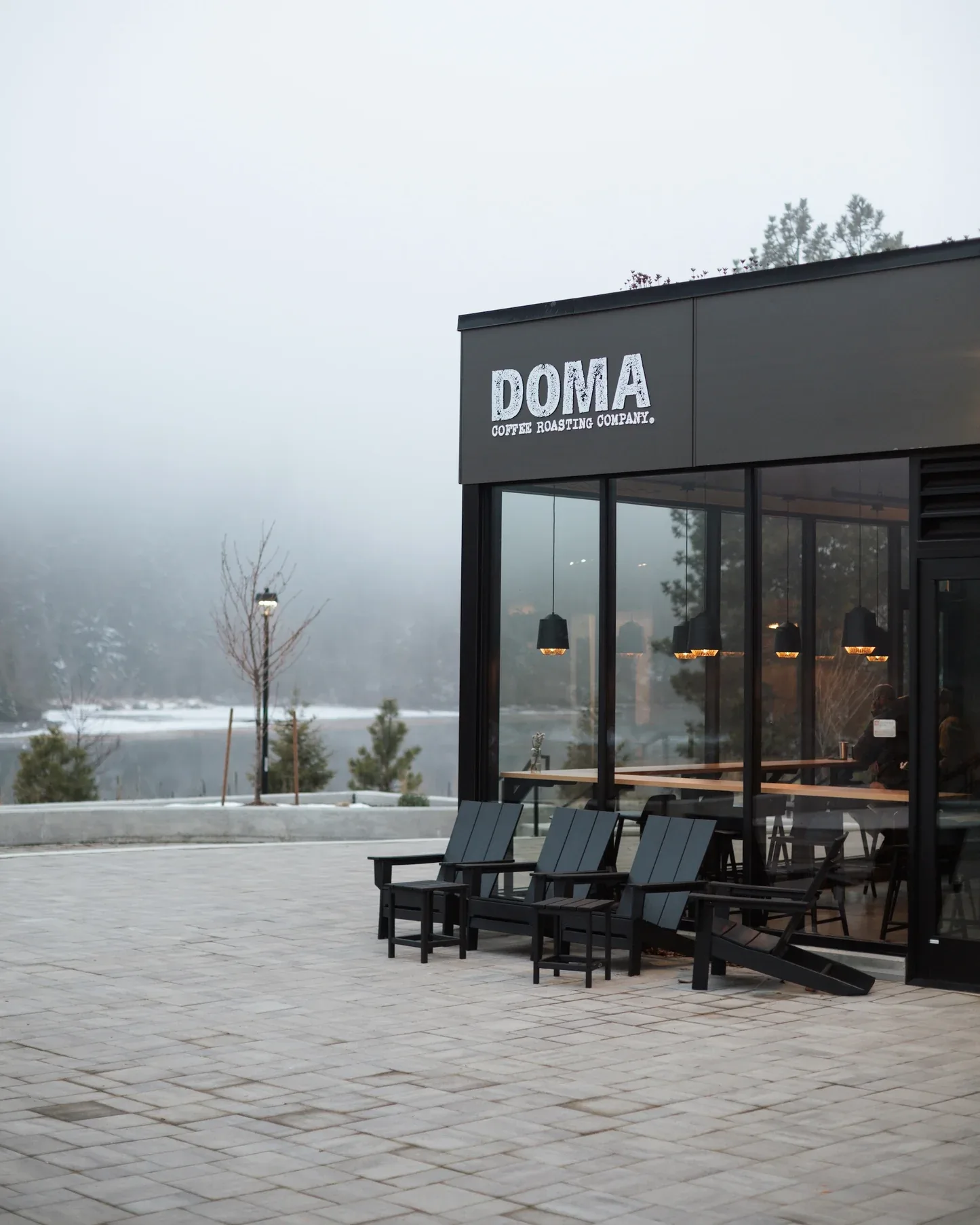 doma coffee shop with adirondack chairs overlooking misty lakeside landscape., doma coffee roasting company, coeur d'alene