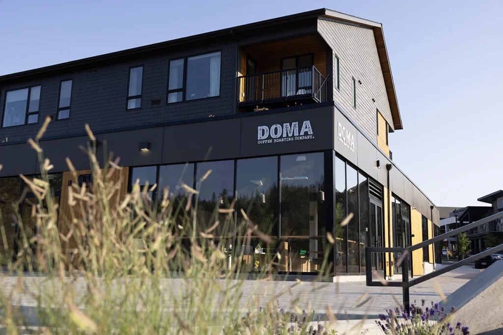 modern black building with "doma coffee roasters company" signage and upper residential space., doma coffee roasting company,