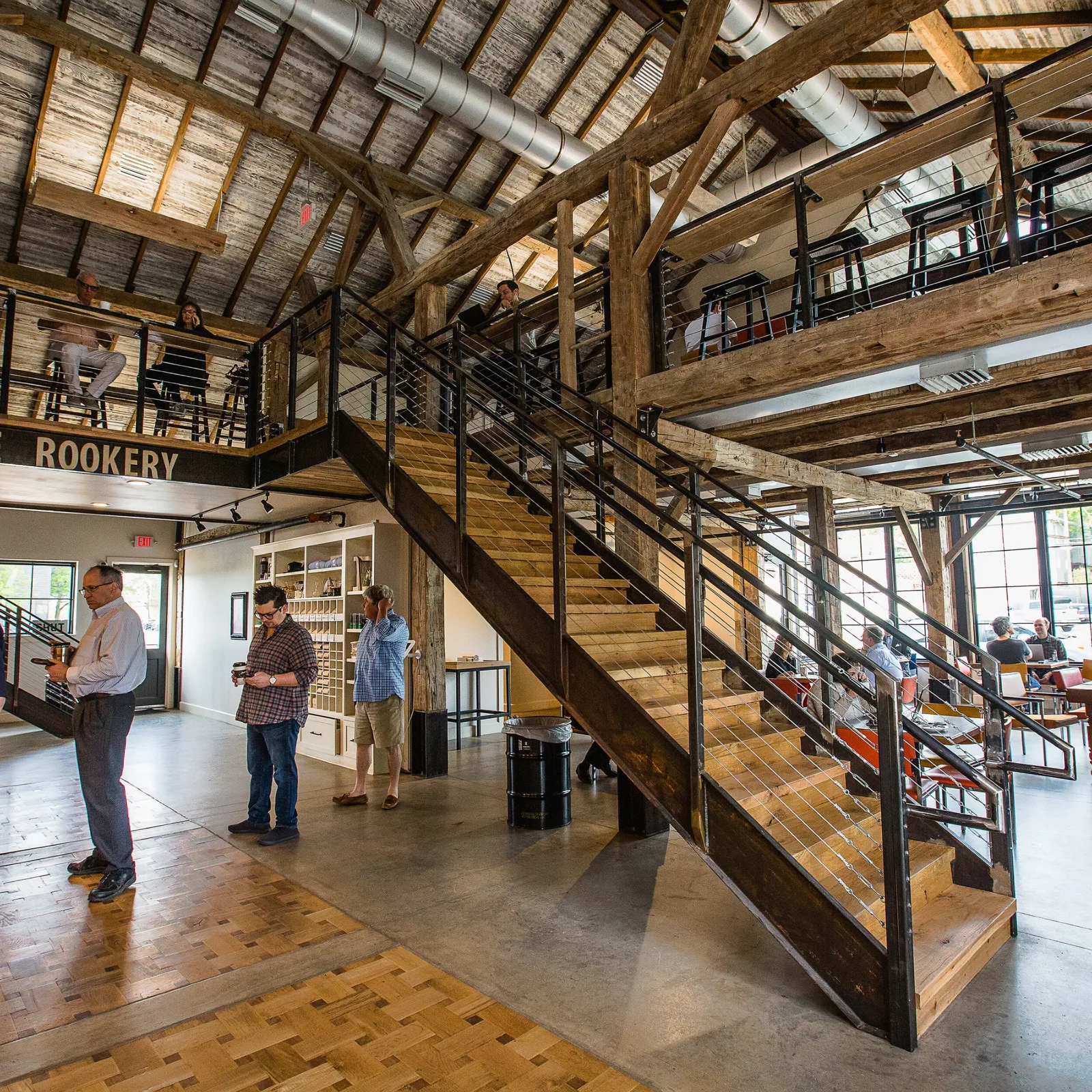 rustic barn interior with wooden beams, metal railings, and visitors on multiple levels., doubleshot coffee co, oklahoma