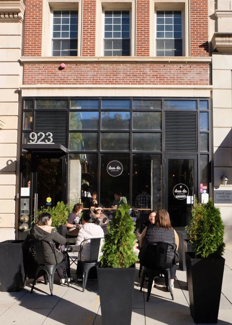 modern café storefront at 923 with outdoor seating and customers dining., dua dc, washington