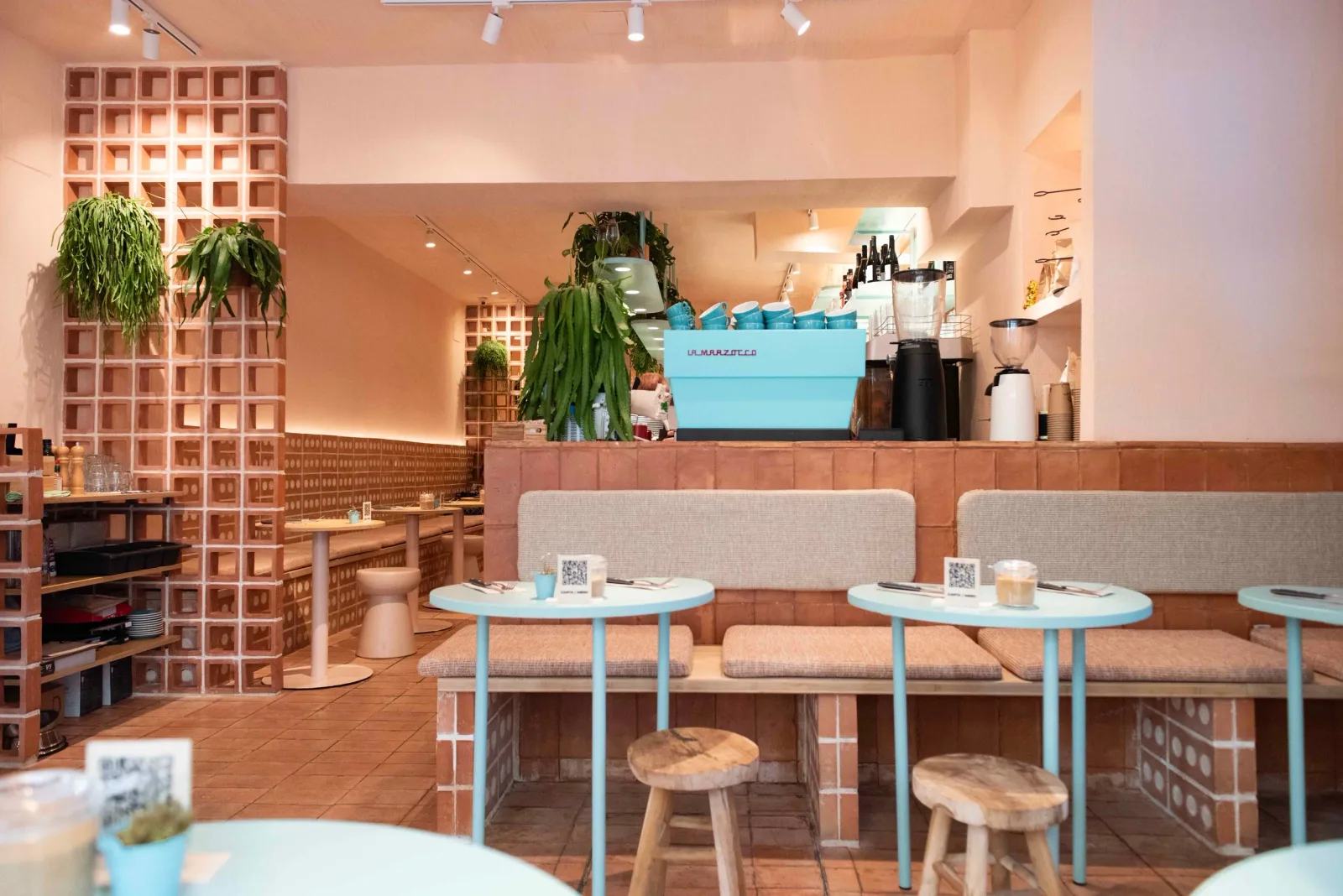 modern café interior with terracotta brick, turquoise tables, and hanging plants., eatmytrip specialty coffee & brunch barcel