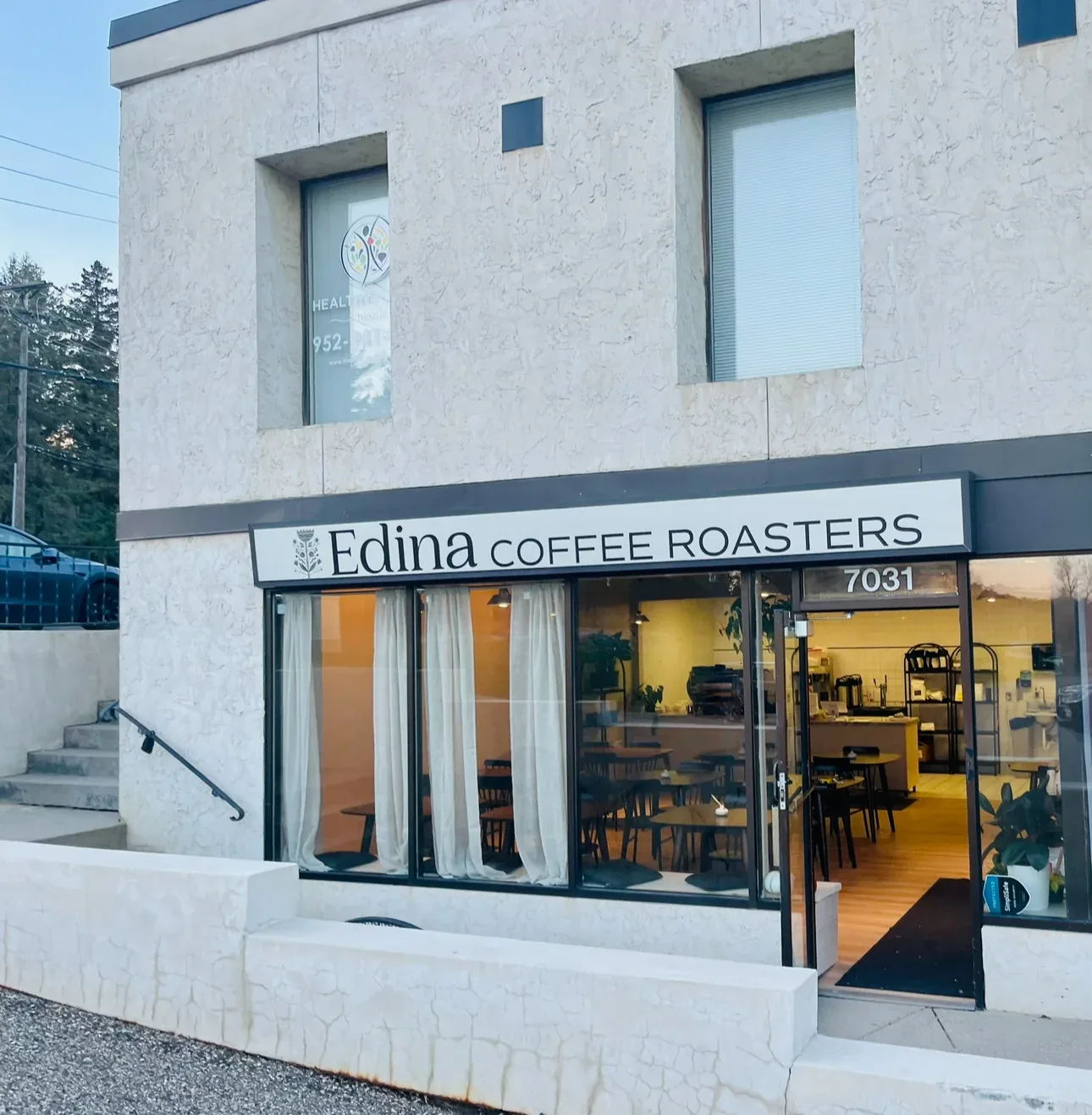 edina coffee roasters storefront with modern minimalist architecture and warm interior lighting., edina coffee roasters, edin