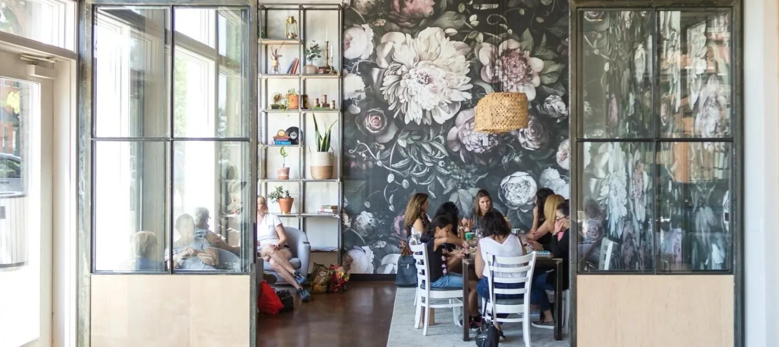 group of women dining at table with floral wallpaper backdrop and glass doors., edison coffee co roastery, lewisville