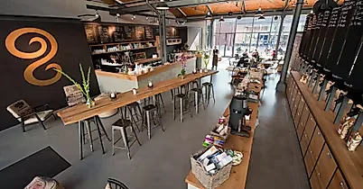 modern office or café space with wooden tables, bar seating, and orange branding., elbgold city, hamburg