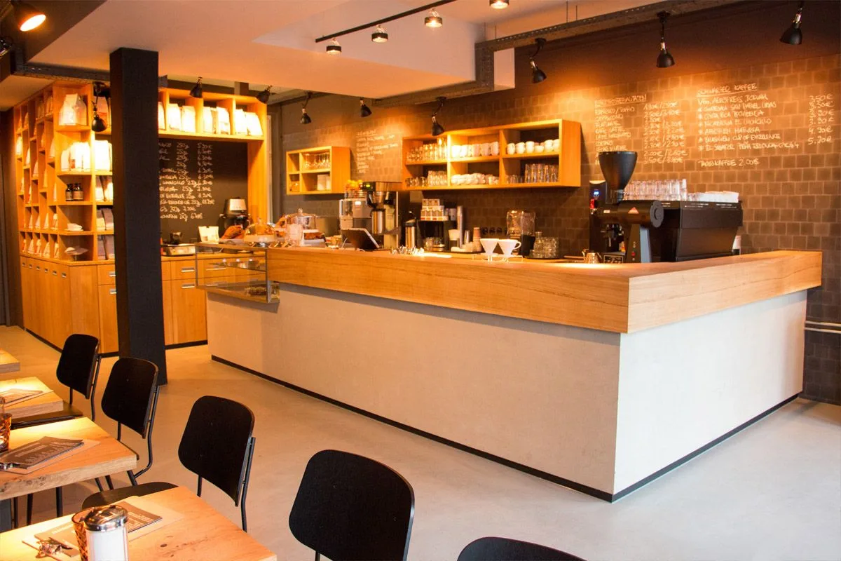 modern coffee shop interior with wooden counter, orange shelving, and chalkboard menu., elbgold city, hamburg