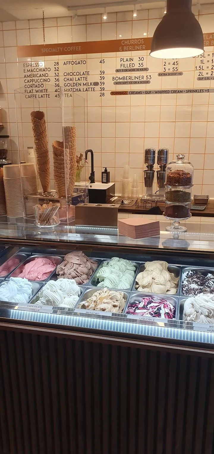 gelato shop counter with colorful ice cream flavors and coffee menu board above., elis copenhagen, copenhagen