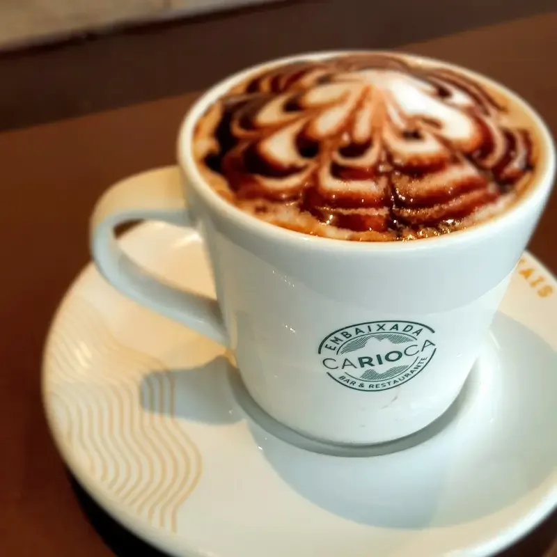 latte with decorative latte art in white ceramic cup on saucer., embaixada carioca, rio de janeiro