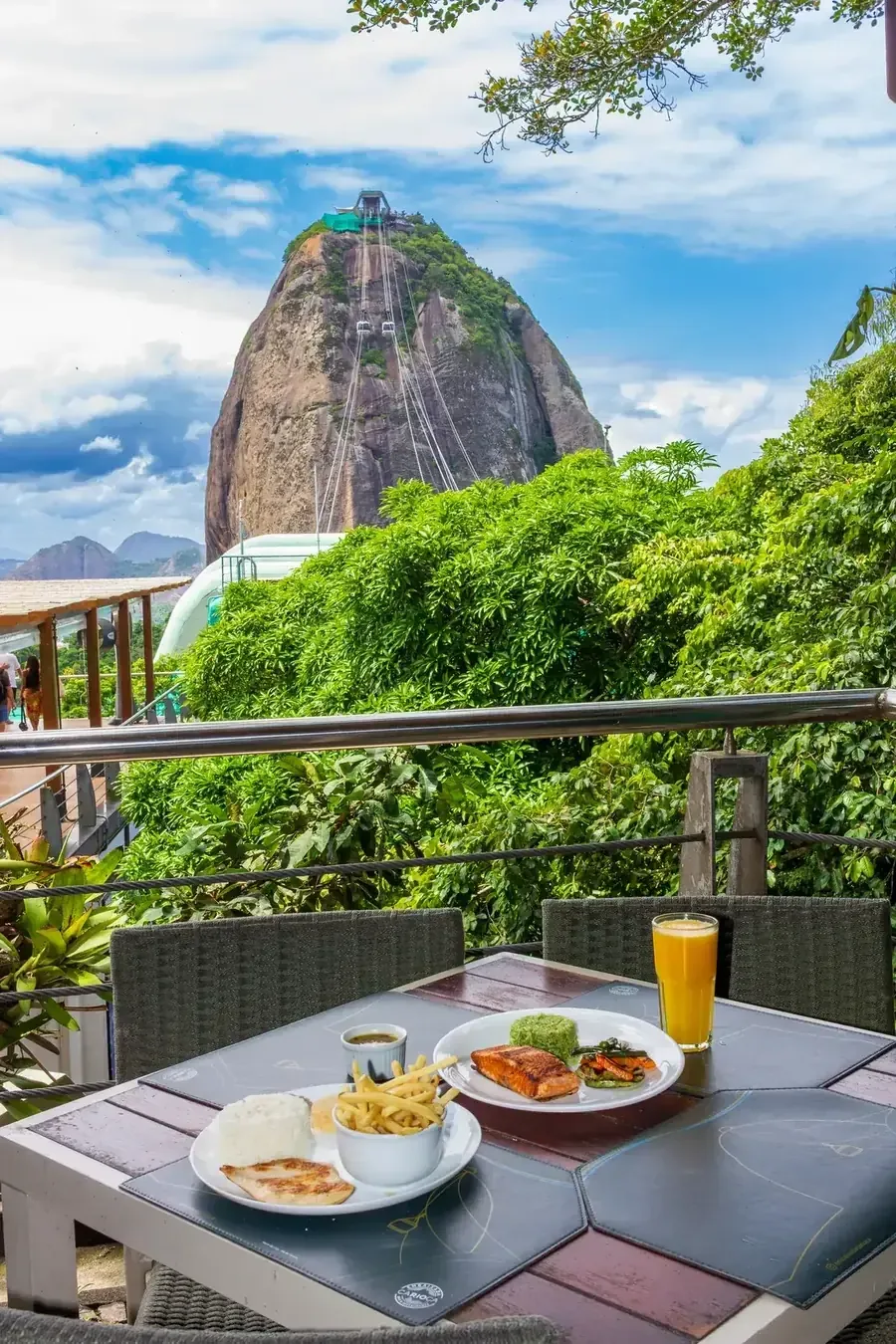 dining table with meals overlooking massive rock formation and cable car., embaixada carioca, rio de janeiro
