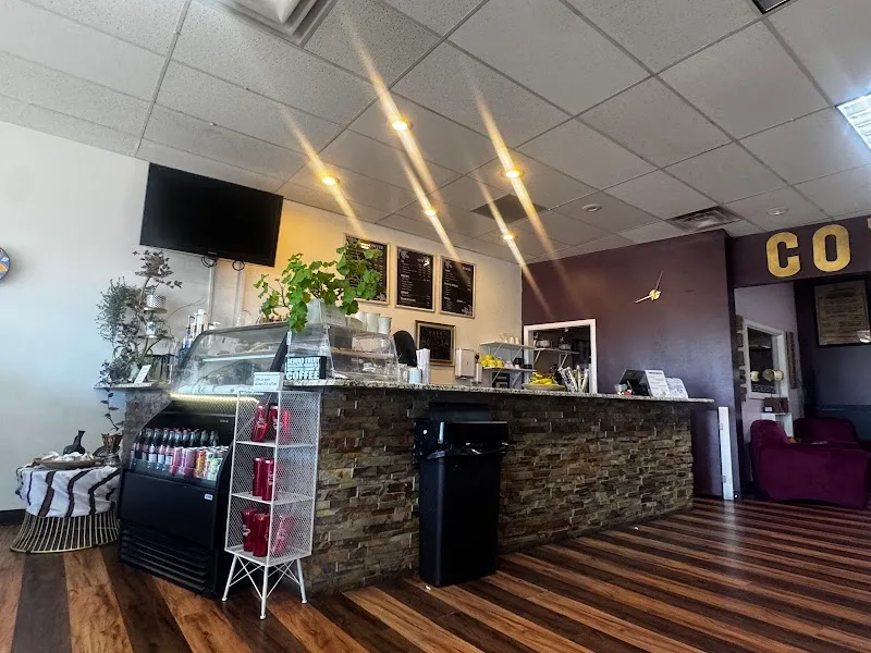 coffee shop interior with counter, plants, menu boards, and warm lighting fixtures., endless grind coffee, aurora