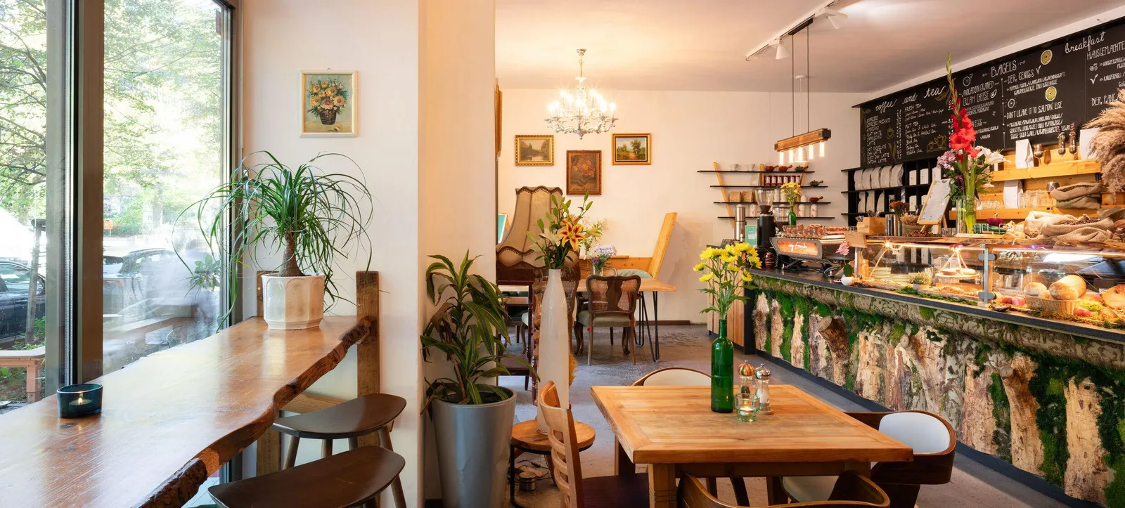 charming café interior with counter service, wooden tables, plants, and vintage décor., ewig freunde, berlin
