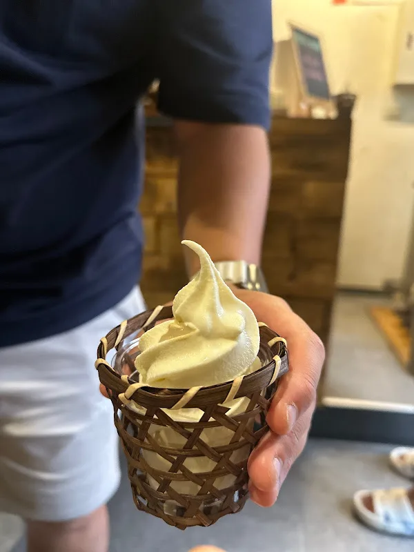 person holding soft serve ice cream cone with chocolate waffle wrapper in indoor setting., 京美人甘味屋（立食制，霜淇淋口味請見fb、ig粉專）, tainan