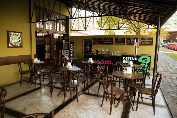 yellow-walled café with wooden chairs, tables, and "defend bees" signage., festval parkshoppingbarigui, curitiba