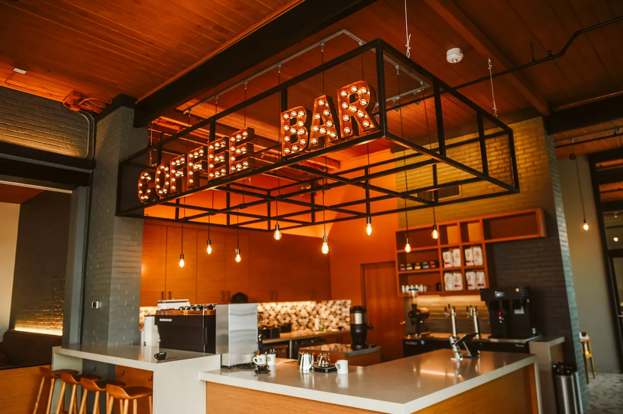 modern orange café interior with illuminated marquee signage and pendant lights., fidel & co coffee roasters, little rock