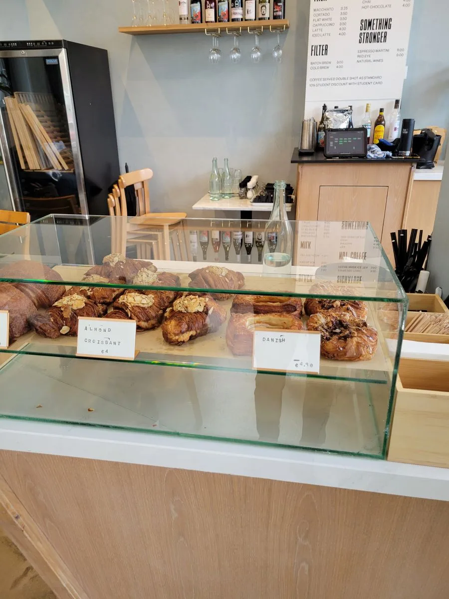 bakery counter with pastries, almond croissants, and danish pastries displayed behind glass., five ways coffee roasters, amst