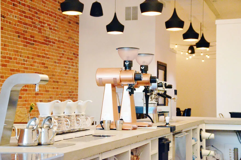 modern coffee shop interior with espresso machine, pendant lights, and brick wall., flatlands coffee, bowling green