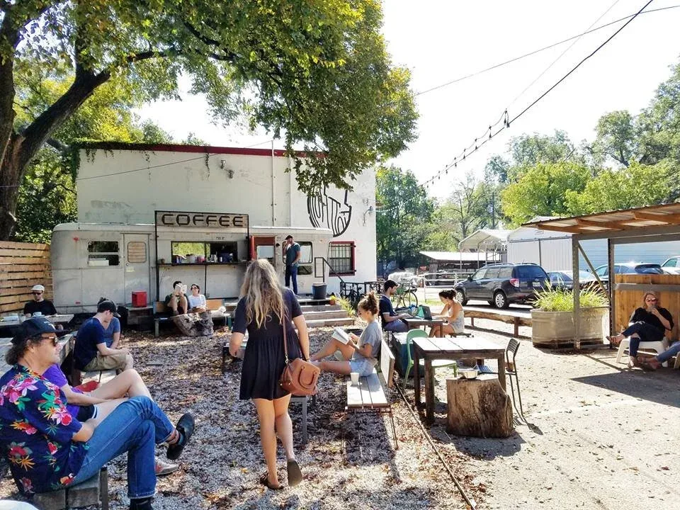 outdoor community gathering around vintage coffee trailer on gravel lot., flitch coffee, austin