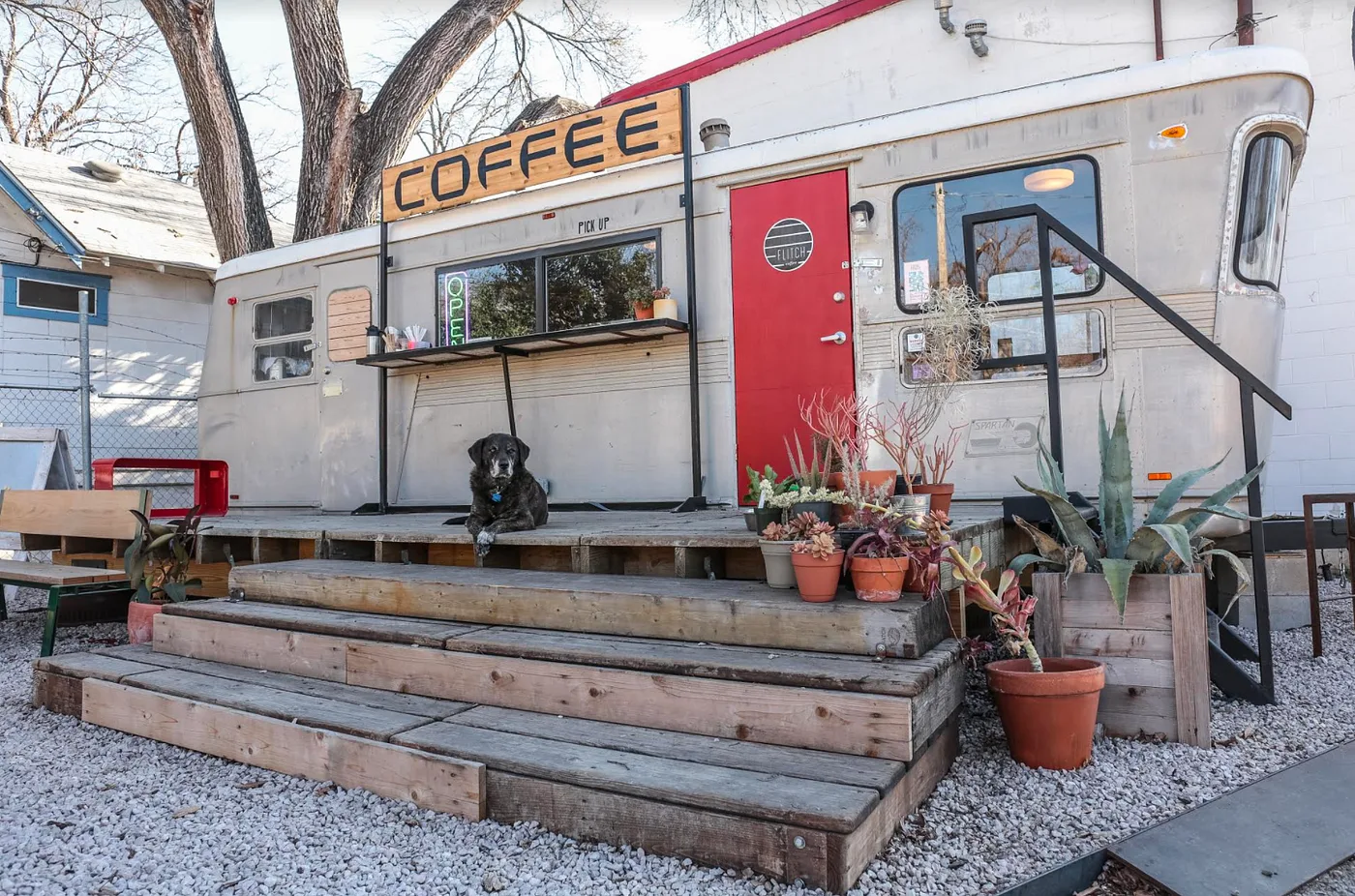 coffee shop in a vintage silver trailer with black dog and potted plants., flitch coffee, austin