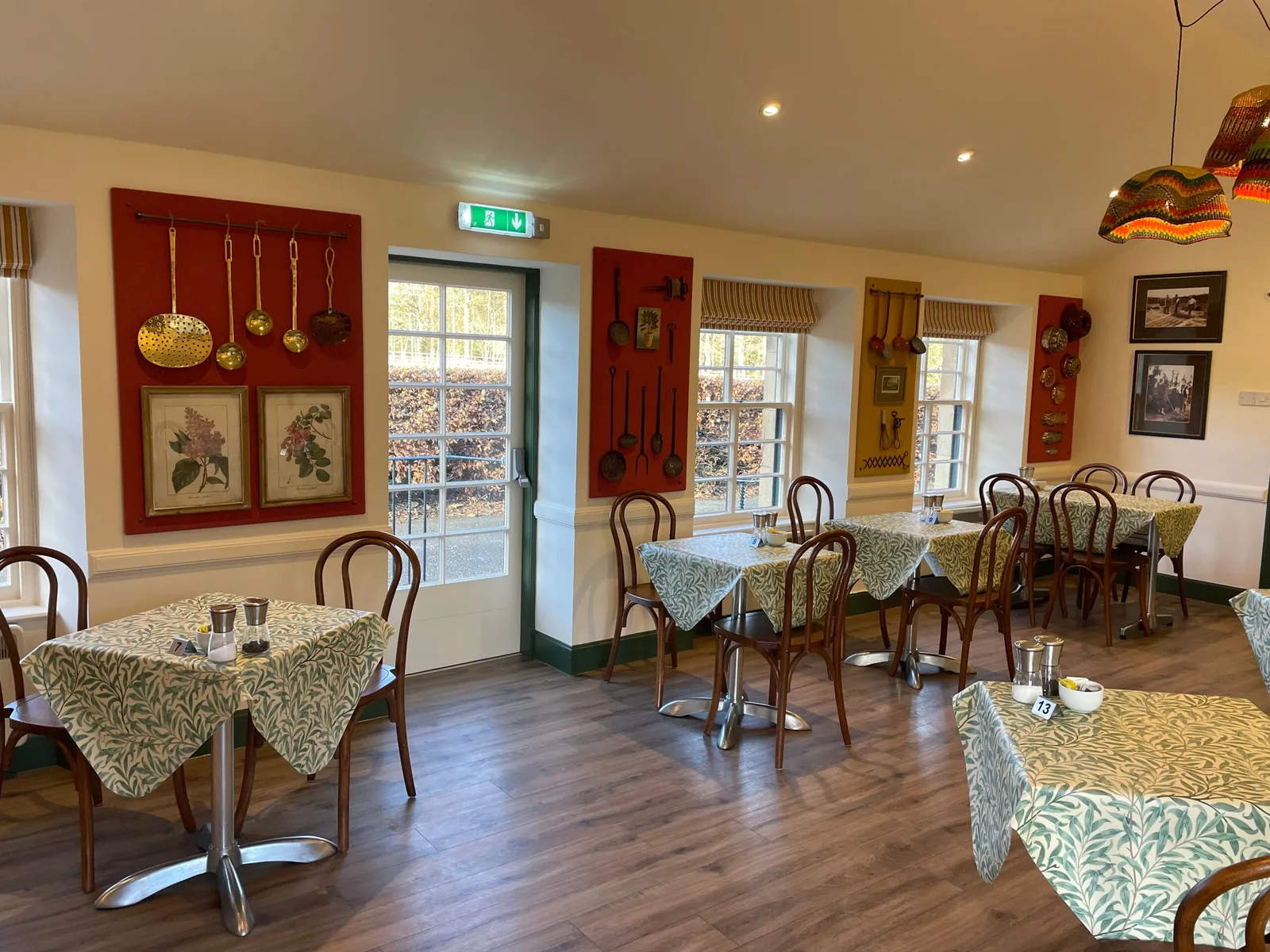 warm dining room with round tables, bentwood chairs, and red wall décor., floors castle, newtown st boswells