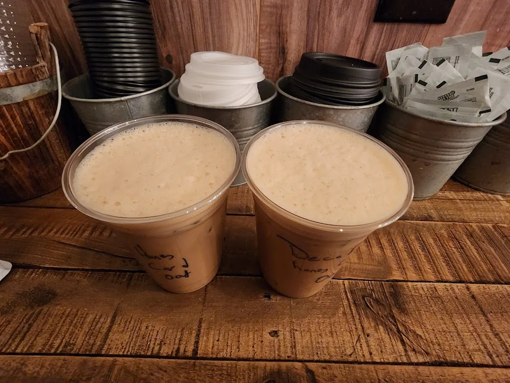 two iced coffee drinks with handwritten labels on wooden counter., flux coffee, oyster bay