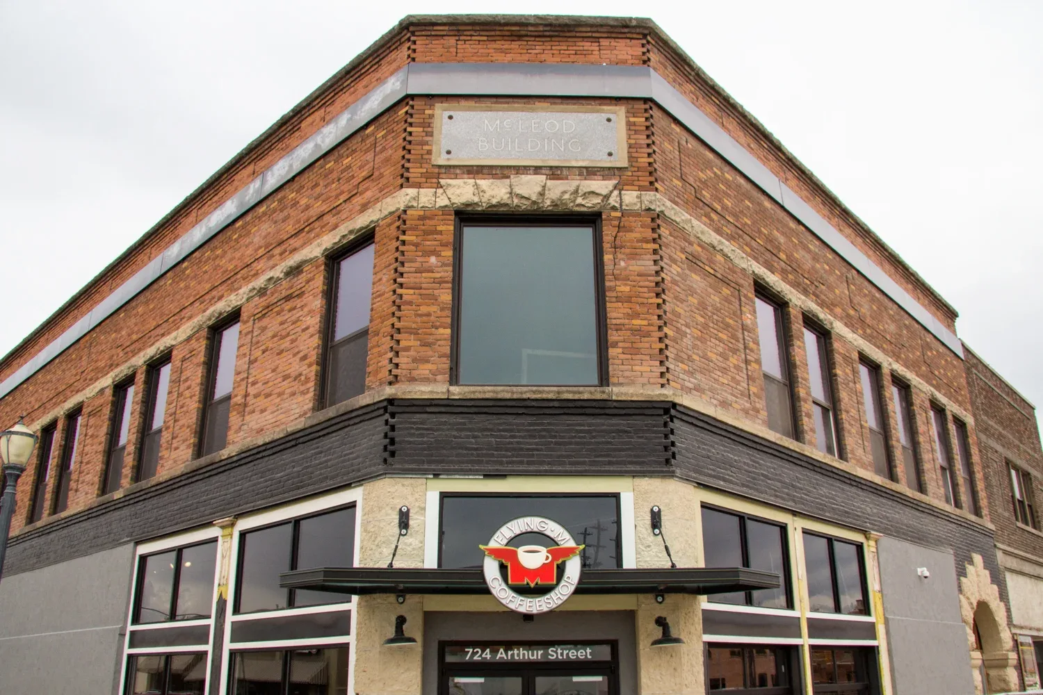 historic brick building with "melody building" plaque and coffee shop below., flying m coffee garage, idaho