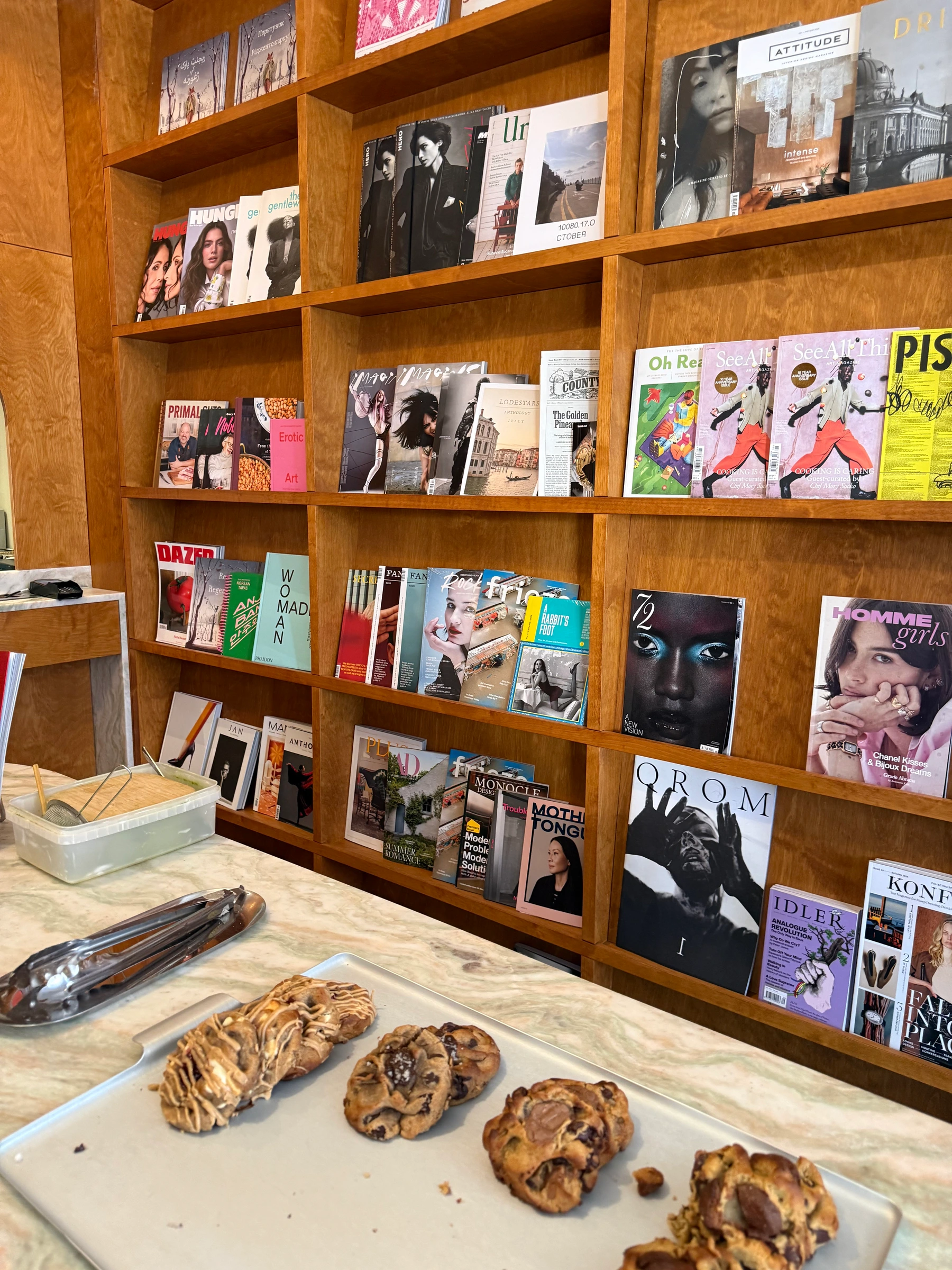 Foreign Exchange interior — magazine rack and cookies on marble counter
