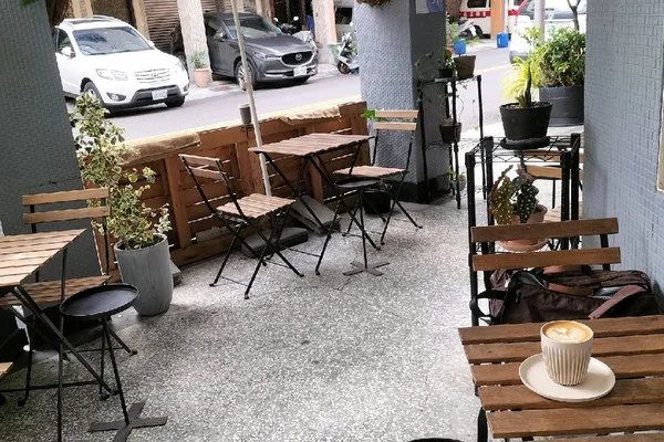 outdoor café seating area with wooden benches, potted plants, and coffee cup., formula coffee roaster, kaohsiung