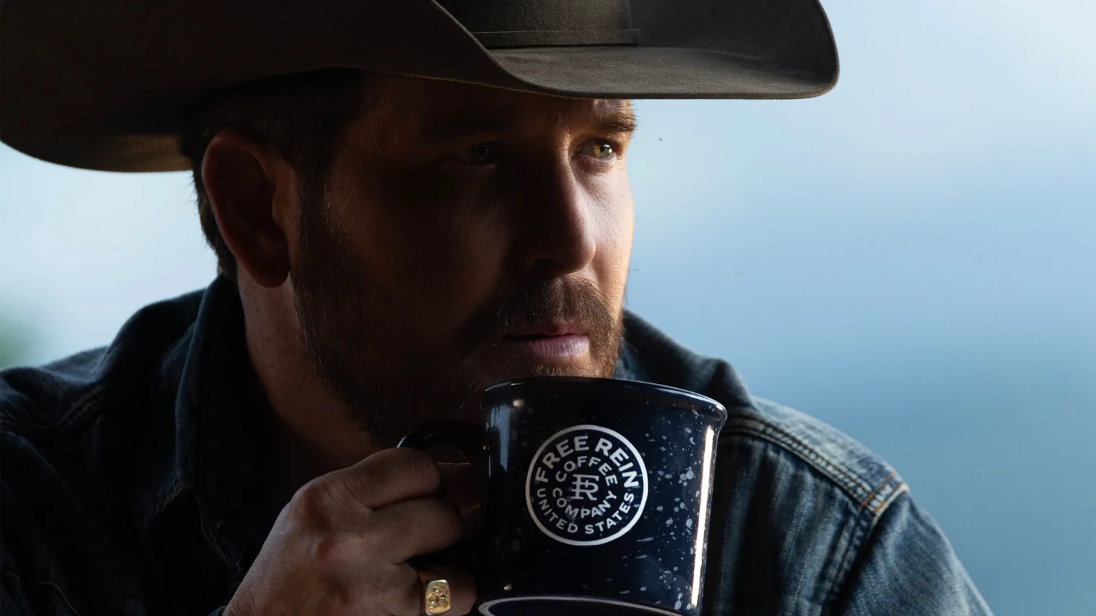 bearded cowboy in black hat holding enamel camping mug outdoors., free rein coffee, san angelo