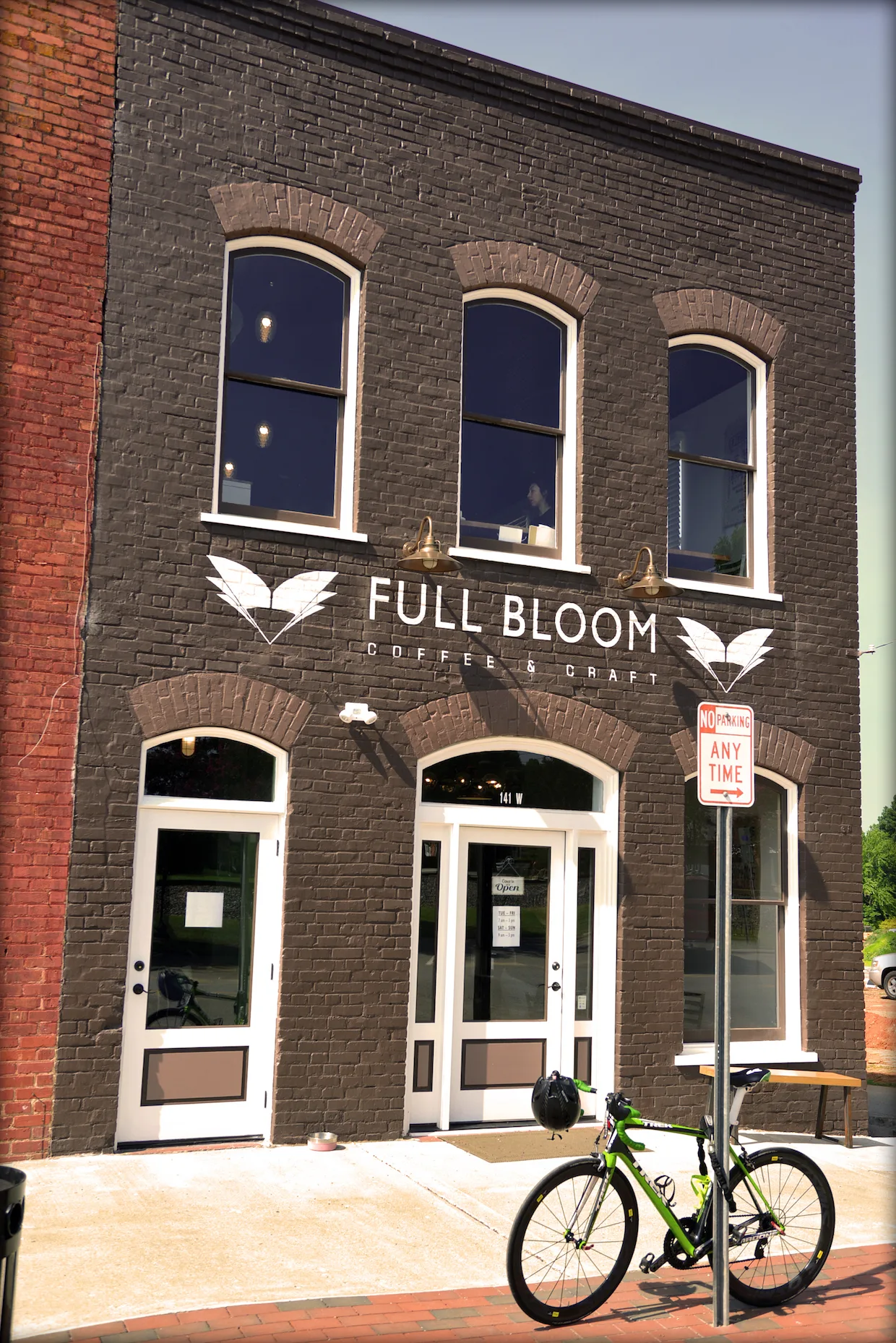 dark brick storefront with "full bloom coffee & craft" signage and arched windows., full bloom coffee roasters, north carolin