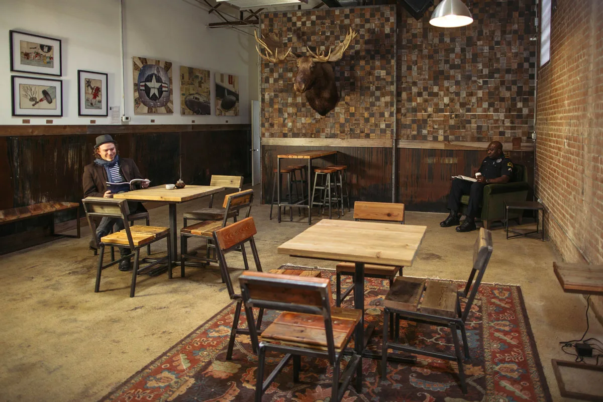 industrial loft space with wooden furniture, brick walls, and taxidermied moose head., full city rooster, dallas