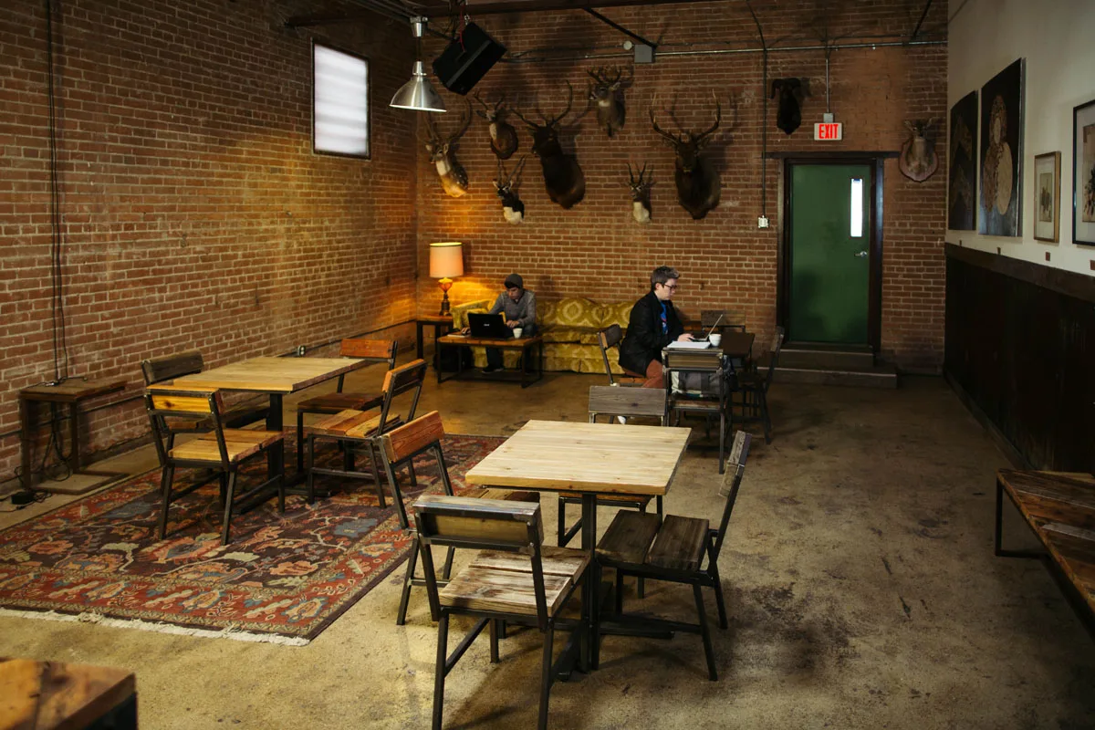 industrial brick loft with taxidermy, wooden tables, and working patrons., full city rooster, dallas