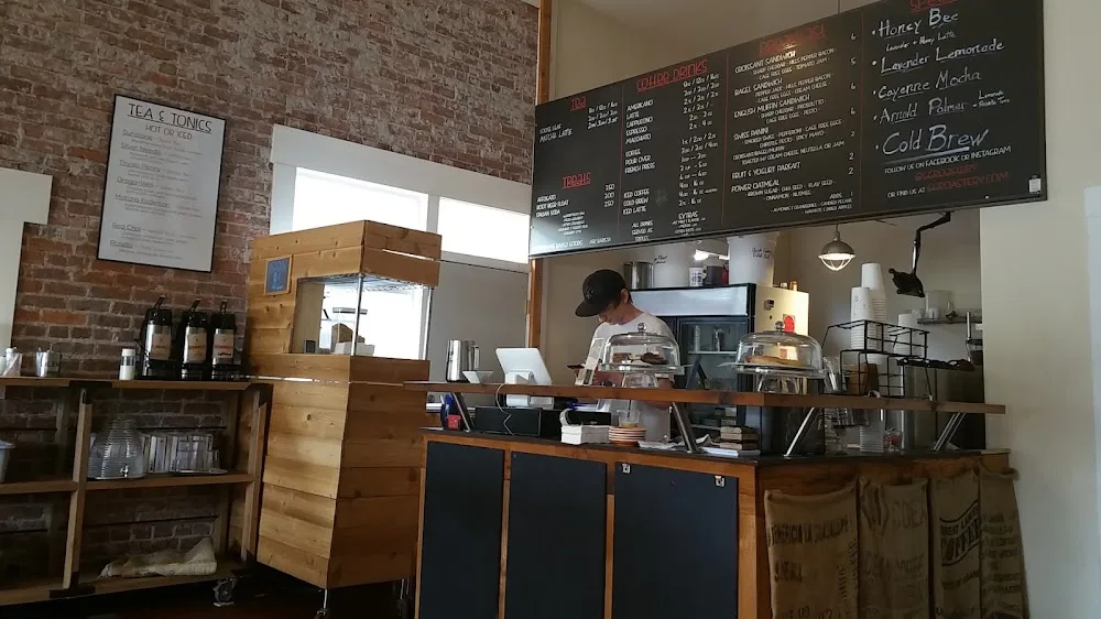 coffee shop interior with brick walls, menu boards, and barista at counter., gathering grounds cafe & roastery, klamath falls