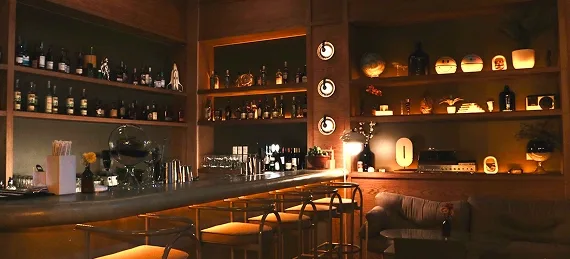 modern bar interior with illuminated shelving, counter seating, warm ambient lighting throughout., general cafe bar medellín,